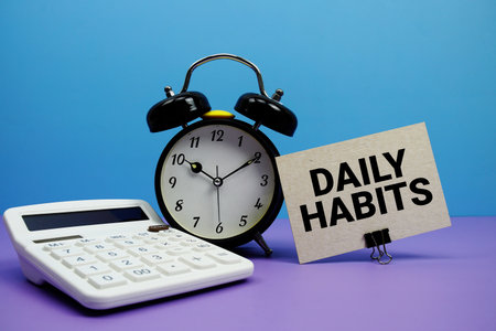 Daily Habits text with calculator and alarm clock on blue and purple backgroundの写真素材