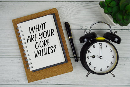 What Are Your Core Values? text written on notepad with alarm clock on wooden background