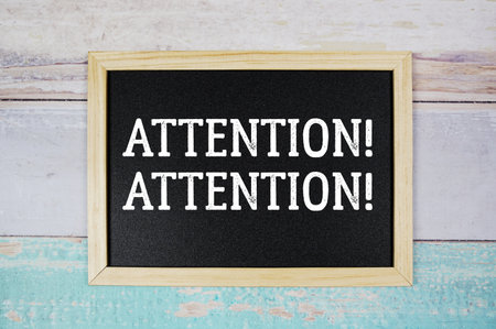 Attention! Attention! text with blackboard on wooden backgroundの写真素材