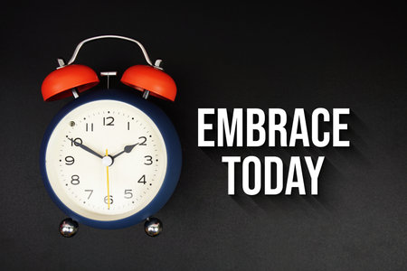 Embrace Today text with alarm clock on black backgroundの写真素材