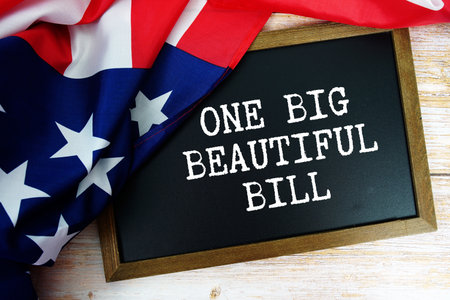 American flag with blackboard  "OBBB The One Big Beautiful Bill Act" on wooden backgroundの写真素材