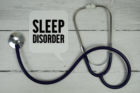 Sleep Disorder text with Medical Stethoscope on wooden backgroundの写真素材