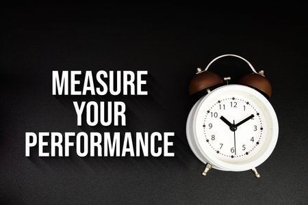 Measure Your Performance text with alarm clock on black background