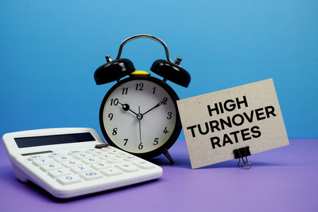 High Turnover Rates text with calculator and alarm clock on blue and purple backgroundの写真素材