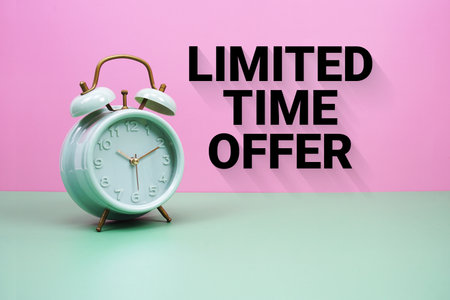 Black alarm clock on a pastel green and pink background with the text "Limited Time Offer"の写真素材