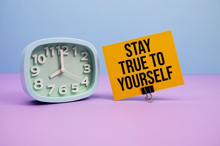 Stay True To Yourself text and alarm clock on blue and purple backgroundの写真素材