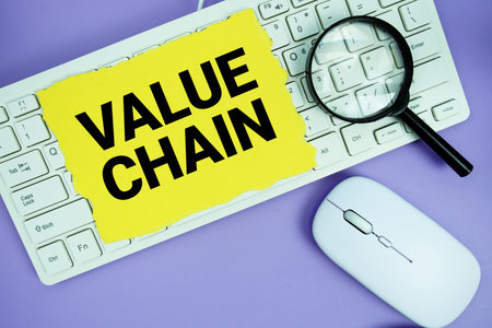 Yellow torn paper with the text Value Chain placed on a white keyboard, and magnifying glass and a...