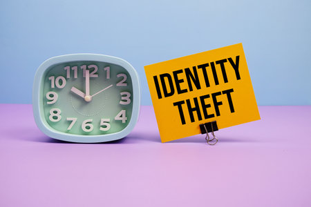 Identity Theft text and alarm clock on blue and purple backgroundの写真素材