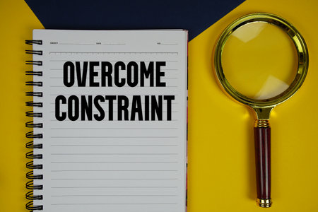 Overcome Constraint text with magnifying glass on yellow backgroundの写真素材