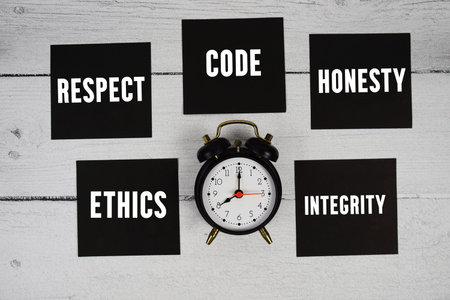 Ethics, Respect, Code, Honesty, Integrity text written on sticky note and alarm clock flat lay on...