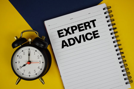 Expert Advice text written on notepad with alarm clock on yellow backgroundの写真素材