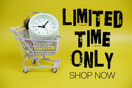 Limited Time Only text with trolley shopping cart and alarm clock on yellow backgroundの写真素材