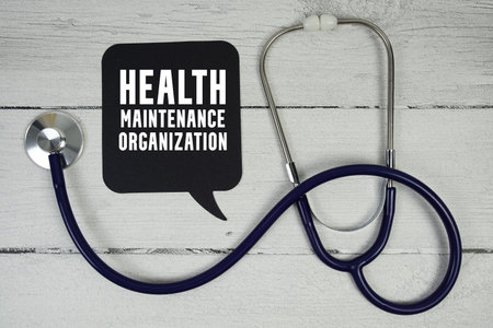 HMO Health Maintenance Organization text with Medical Stethoscope on wooden backgroundの写真素材