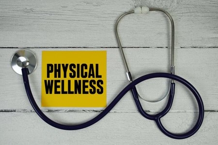 Physical Wellness text with Magnifying glass and Medical Stethoscope on wooden backgroundの写真素材