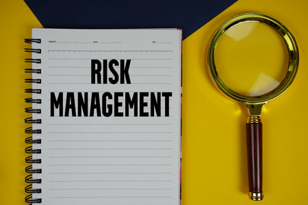 Risk Management text with magnifying glass on yellow backgroundの写真素材