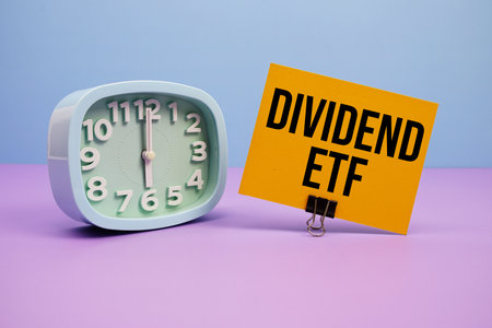 Dividend ETF text and alarm clock on blue and purple backgroundの写真素材