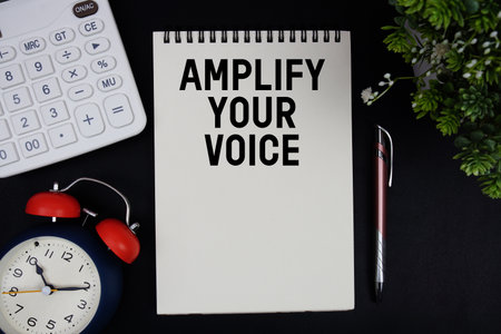 Amplify Your Voice text with calculator with alarm clock on black backgroundの写真素材