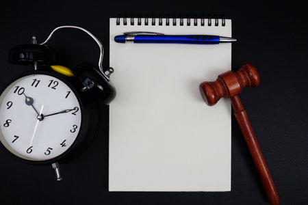 Product Liability text written on notepad with gavel and alarm clock on black backgroundの写真素材