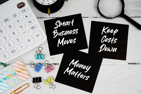 Smart Business Moves, Keep Costs Down, Money Matters text written on paper note with calculator and...