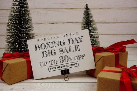 Festive display with small decorative Christmas trees and gift box present with "Special Offer Boxing Day Big Sale up to 30% off, Promotion Holiday Sale Eventの写真素材