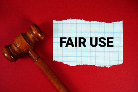 Fair Use text written on rip paper with wooden judgment gavel on red backgroundの写真素材