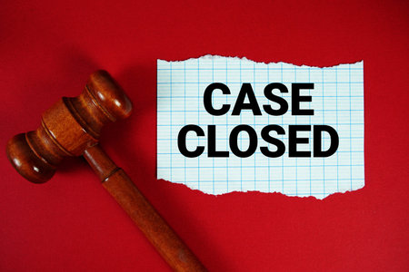 Case Closed text written on rip paper with wooden judgment gavel on red background