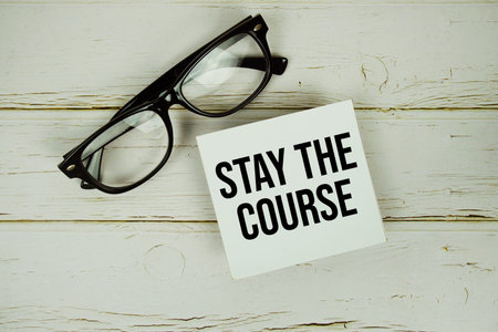 Stay The Course text with eyeglasses on wooden backgroundの写真素材