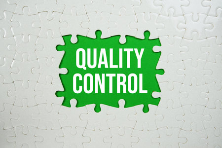 Jigsaw puzzle with a missing piece with "Quality Control" on green backgroundの写真素材