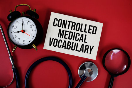 Controlled Medical Vocabulary text written on paper card with stethoscope and alarm clock on red backgroundの写真素材