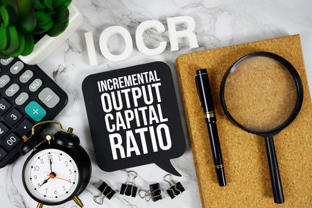 IOCR - Incremental Output Capital Ratio acronym with calculator, alarm clock and magnifying glass,...