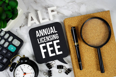 ALF - Annual Licensing Fee acronym with calculator, alarm clock and magnifying glass, Business concept backgroundの写真素材