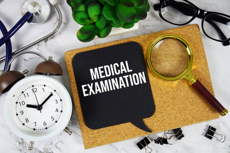 Medical Examination text with alarm clock, calculator and stethoscope on marble backgroundの写真素材