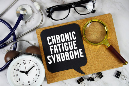 Chronic Fatigue Syndrometext with Stethoscope, alarm clock and magnifying glass on marble backgroundの写真素材
