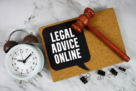 Legal Advice Online text on speech bubble with alarm clock and wooden gavel on marble backgroundの写真素材