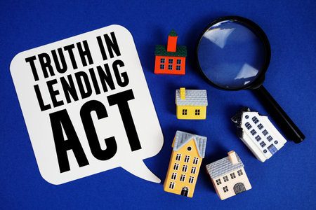 TILA Truth in Lending Act text with house models and magnifying glass on blue backgroundの写真素材