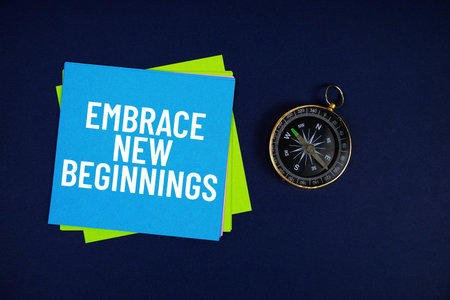 Embrace New Beginnings text written on sticky note with compass on blue  backgroundの写真素材