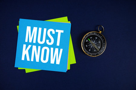 Must Know text written on sticky note with compass on blue  backgroundの写真素材