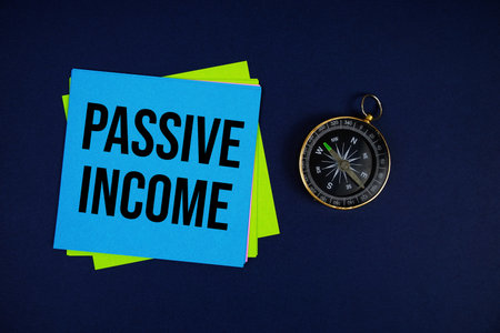 Passive Income text written on sticky note with compass on blue  backgroundの写真素材