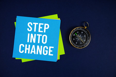 Step Into Change text written on sticky note with compass on blue  backgroundの写真素材