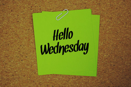 Hello Wednesday text written on sticky note  on wooden cork  backgroundの写真素材