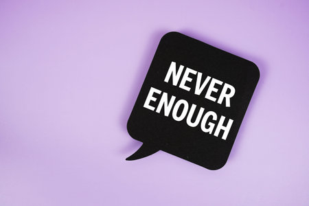 Never Enough text with speech bubble top view on purple background