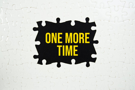 Jigsaw puzzle with a missing piece with "One More Time" on yellow backgroundの写真素材
