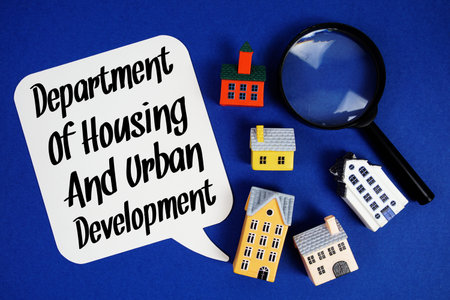 HUD Department of Housing and Urban Development text with house models and magnifying glass on blue...