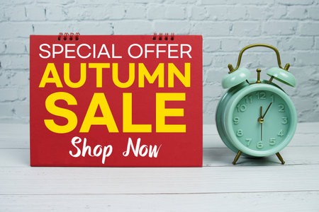 Autumn Sale text Promotion and Marketing with alarm clock on wooden backgroundの写真素材