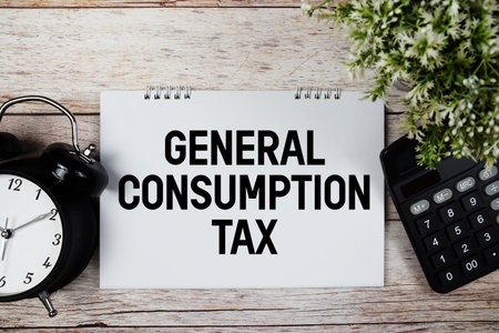 GCT General Consumption Tax text with alarm clock and calculator on wooden backgroundの写真素材