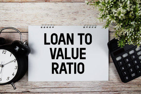 Loan to Value Ratio text with alarm clock and calculator on wooden background
