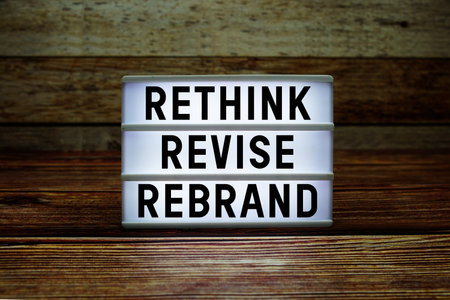 Lightbox with text "Rethink Revise Rebrand" on wooden backgroundの写真素材