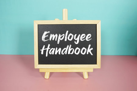 Employee Handbook text on easel blackboard