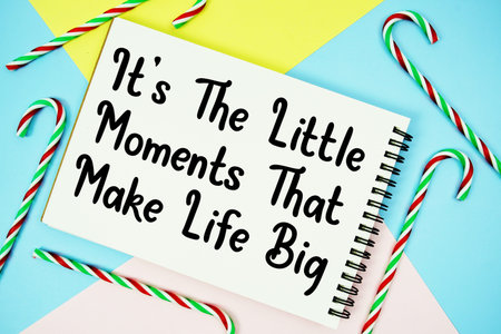 It's The Little Moments That Make Life Big message of season holidays written on notepad with candy...