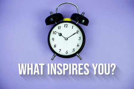 What Inspires You? text and alarm clock on purple background